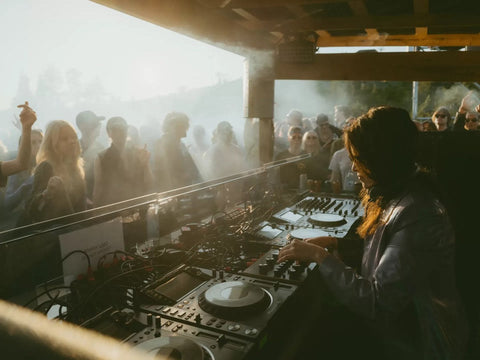 Festival techno en Finlande - DJ aux platines et public au soleil de minuit au Solstice Festival